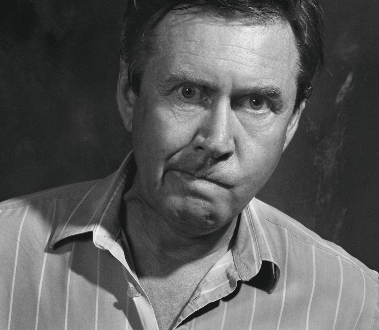 Close-up black and white portrait of a perplexed adult male with quirky expression.